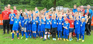 Lassen sich von dem bisschen Regen die Laune nicht verhageln: die 53 Camp-Teilnehmer nebst Trainern, Leiter Michael Stappert, Sparkassen-Mitarbeiterin Sarah Funhoff und Norbert Höning (Union Lüdinghausen/h.v.r.) Foto: WN | flo