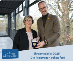 Bürgermeister Ansgar Mertens und Ehrenamtsbeauftragte Dagmar Stein zeigen die Ehrenmedaille der Stadt Lüdinghausen, die am 10. Januar verliehen wird. (C) Stadt Lüdinghausen 